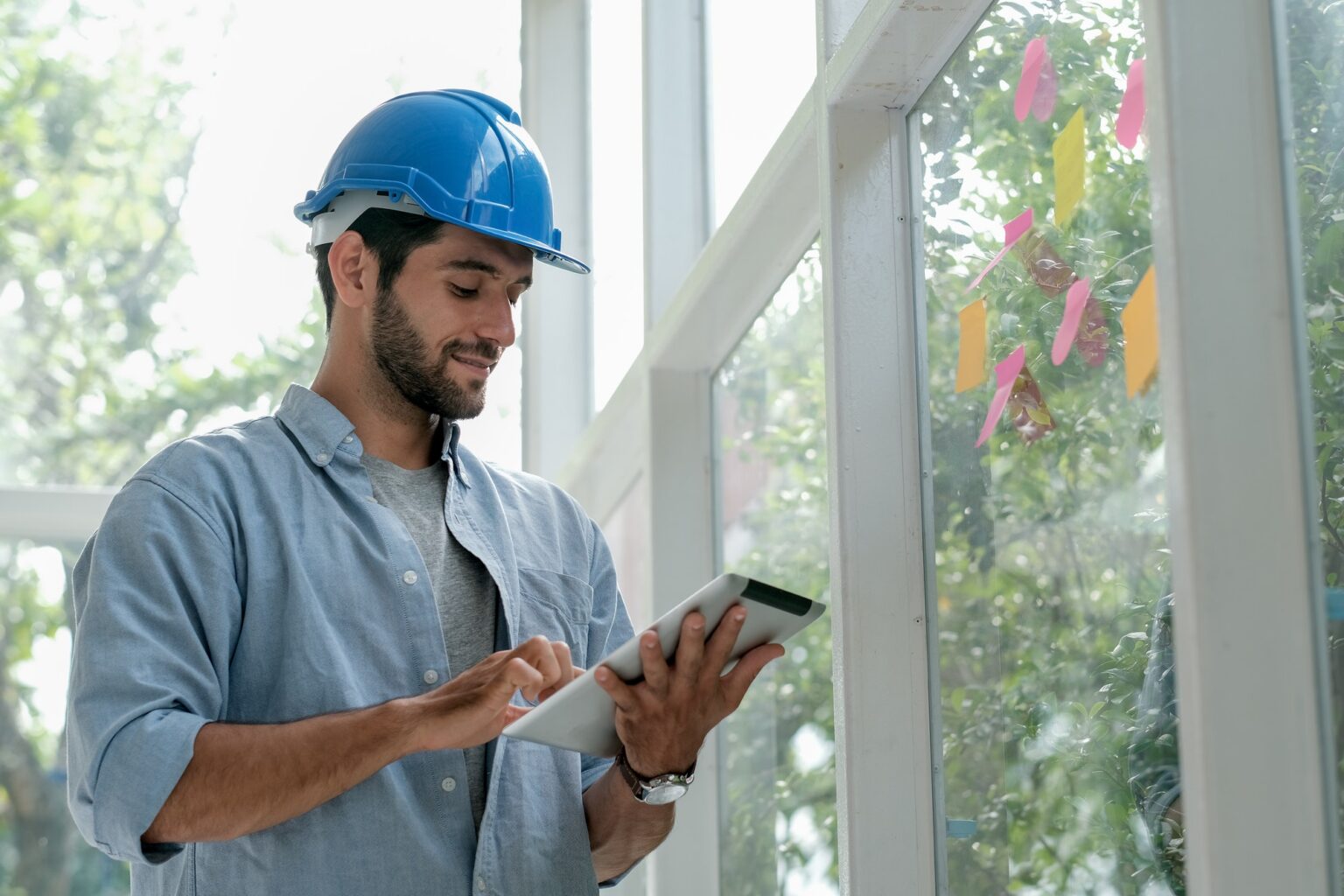 Caucasian engineer work in office with glass windows and use tablet to manage system