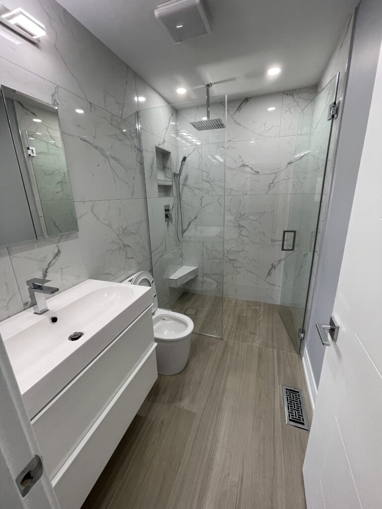 Elegant bathroom with a large freestanding bathtub, walk-in glass shower, double sink vanity, tiled flooring, and a well-lit mirror, emphasizing clean lines and a soothing color palette.