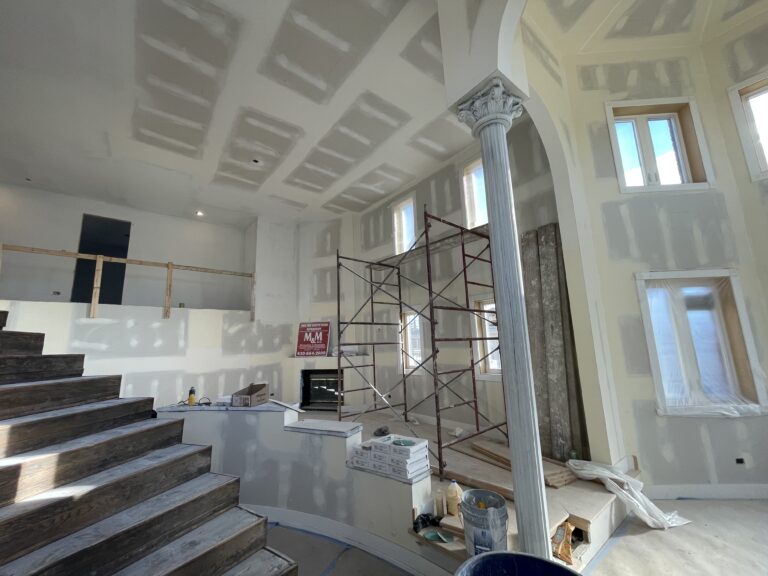 Close-up of hand sanding drywall to prepare for painting in home renovation